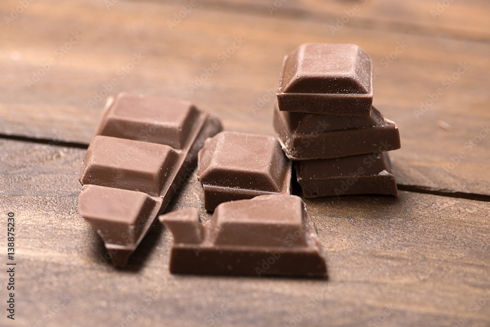 Pieces of chocolate on wooden table. Horizontal shoot. Pieces of chocolate on wooden table. Horizontal shoot.