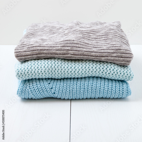 Stack of women's knit cardigans and sweaters.