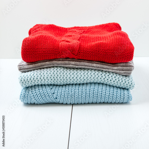 Stack of women's knit cardigans and sweaters.