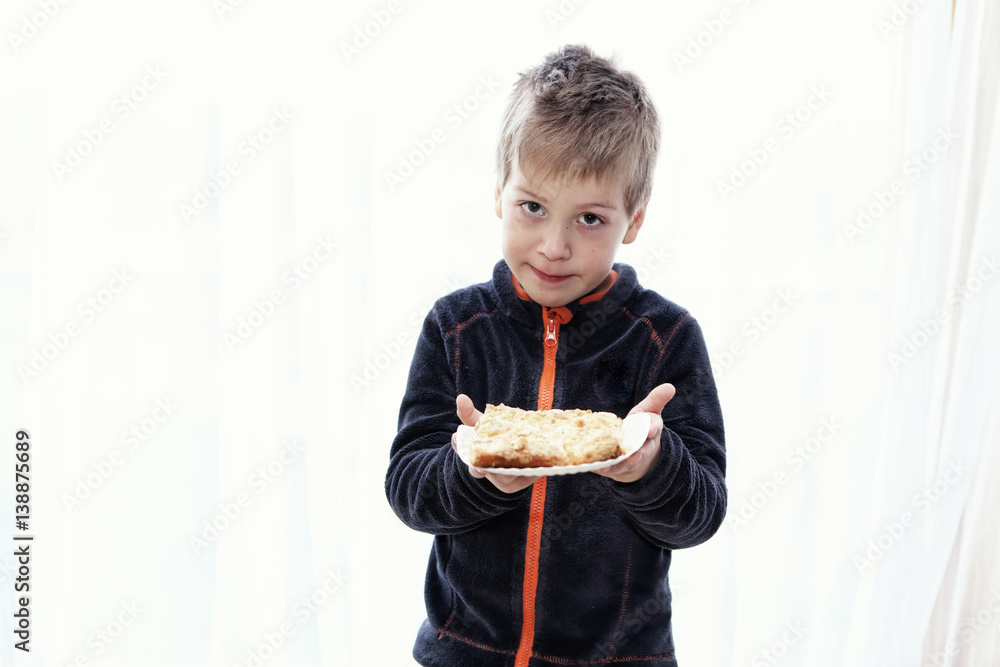 Small boy holding the cake by the white background Small boy holding the cake by the white background