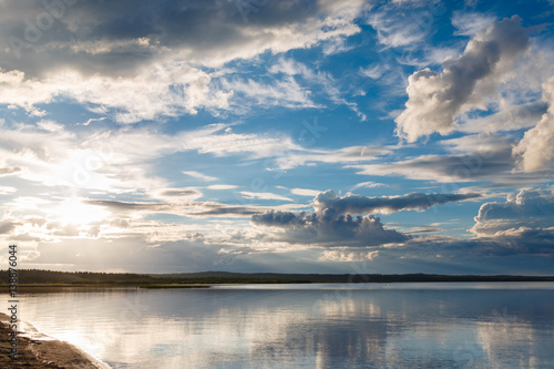 Beautiful sunset on the lake  the clouds reflected in the water. Surface on the lake. Russia  Karelia. Wide photo