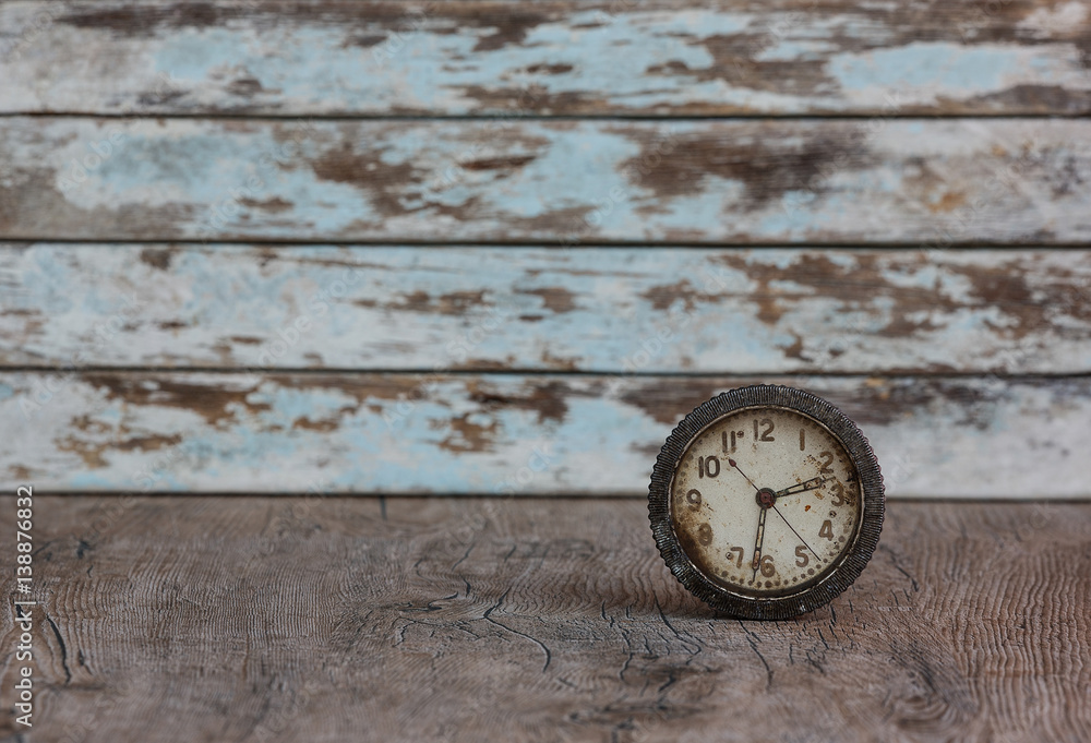 vintage rusty alarm clock on old wooden background