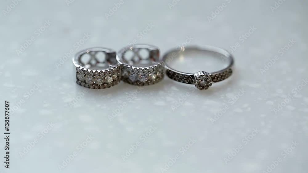 Golden ring and earrings with diamonds on white background Golden ring and earrings with diamonds on white background