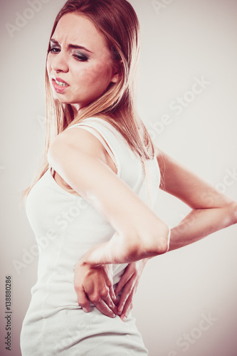 Backache. Young woman suffering from back pain