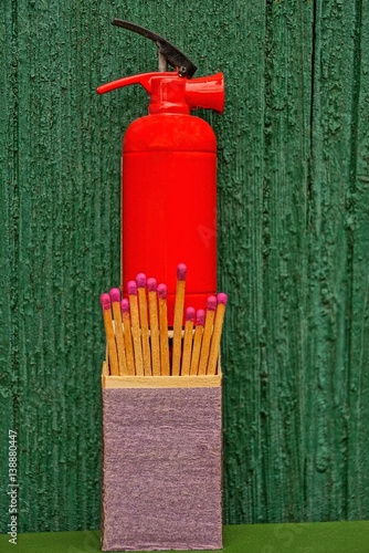 Сувенирный красный огнетушитель и коробок со спичками