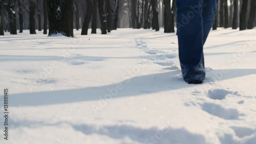 Women's legs walking through the snow in winter time