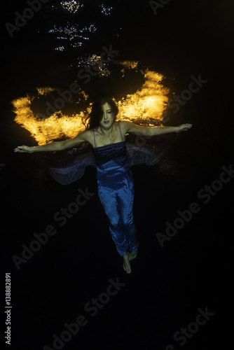 Blue dressed girl with firewings underwater