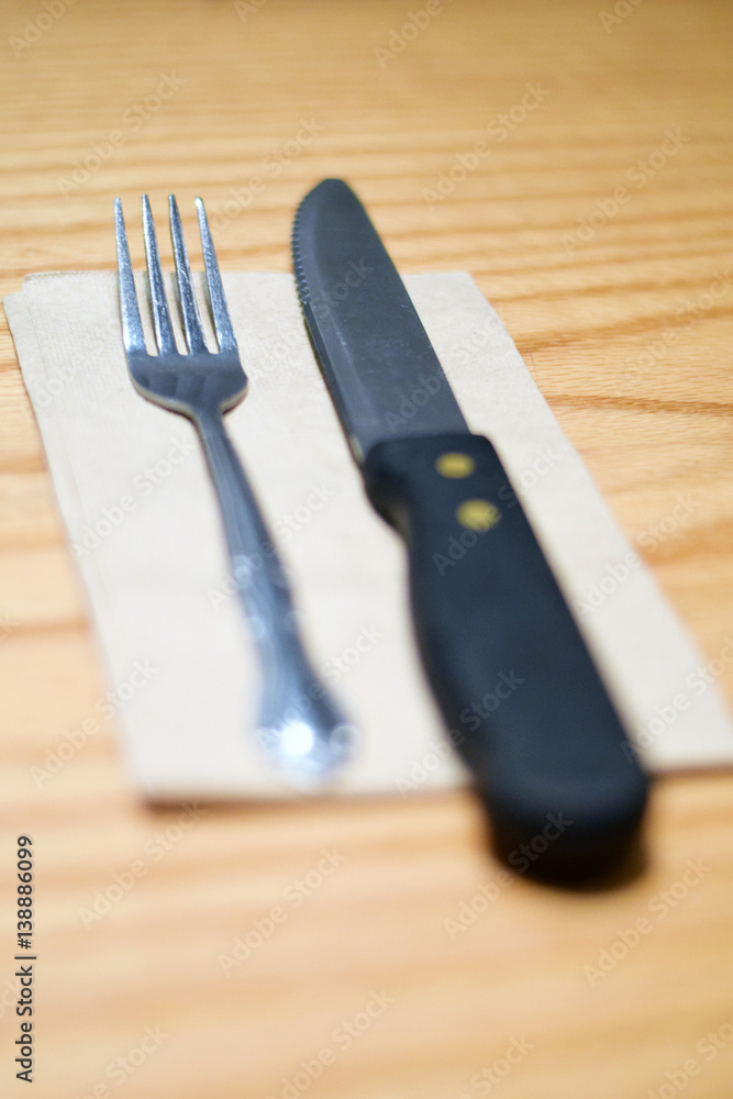 Fork and steak knife on a brown napkin Fork and steak knife on a brown napkin