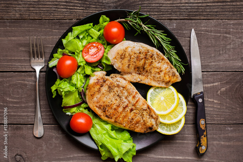 Photography Grilled chicken breast fillet served with herbs, vegetables and