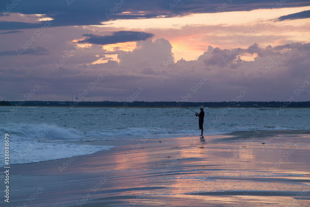 Man fishing at the beach after a storm