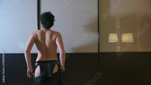 Sexy woman in thong opens the closet to choose clothes