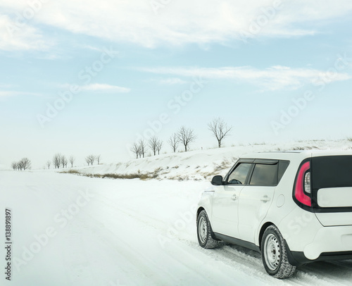 Modern car driving on snowy winter road