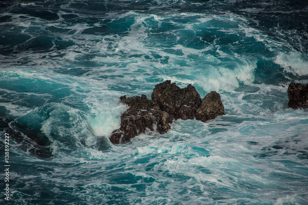 Obraz premium Blue raging waves crashing on the rocks in tne Atlantic ocean