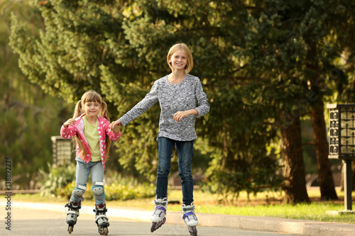 Cute girls on roller skates in park