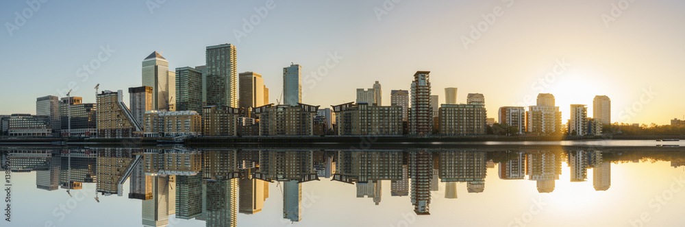 Obraz premium Panorama of Canary Wharf business district with water reflection at sunset