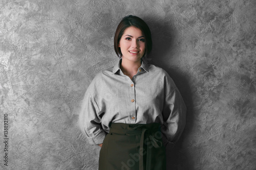 Young woman in brown apron ...