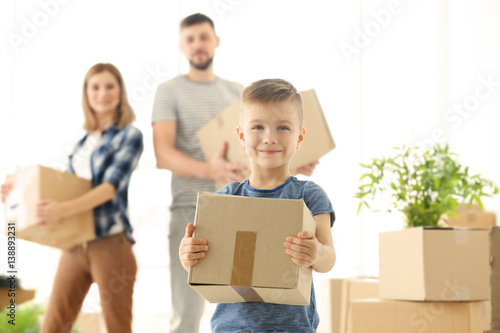 Happy boy with box on blurred background. Moving concept