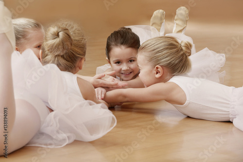 Group of beautiful little ballerinas resting on the floor