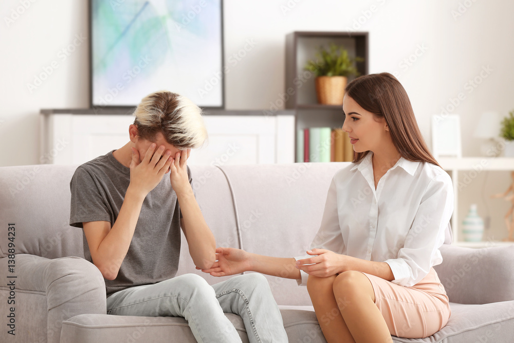 Young female psychologist working with teenager boy in office Young female psychologist working with teenager boy in office