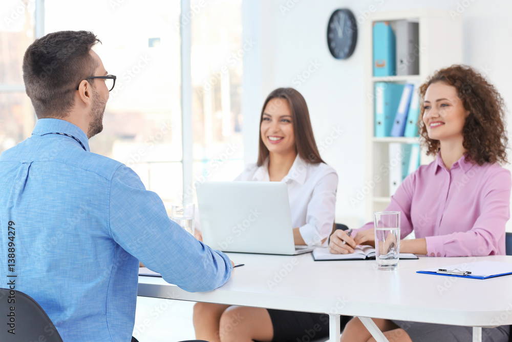 Fototapeta premium Job interview concept. Human resources commission interviewing man