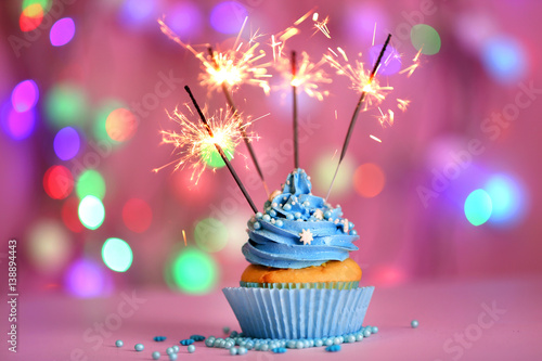 Cupcake with sparkler on defocused lights background