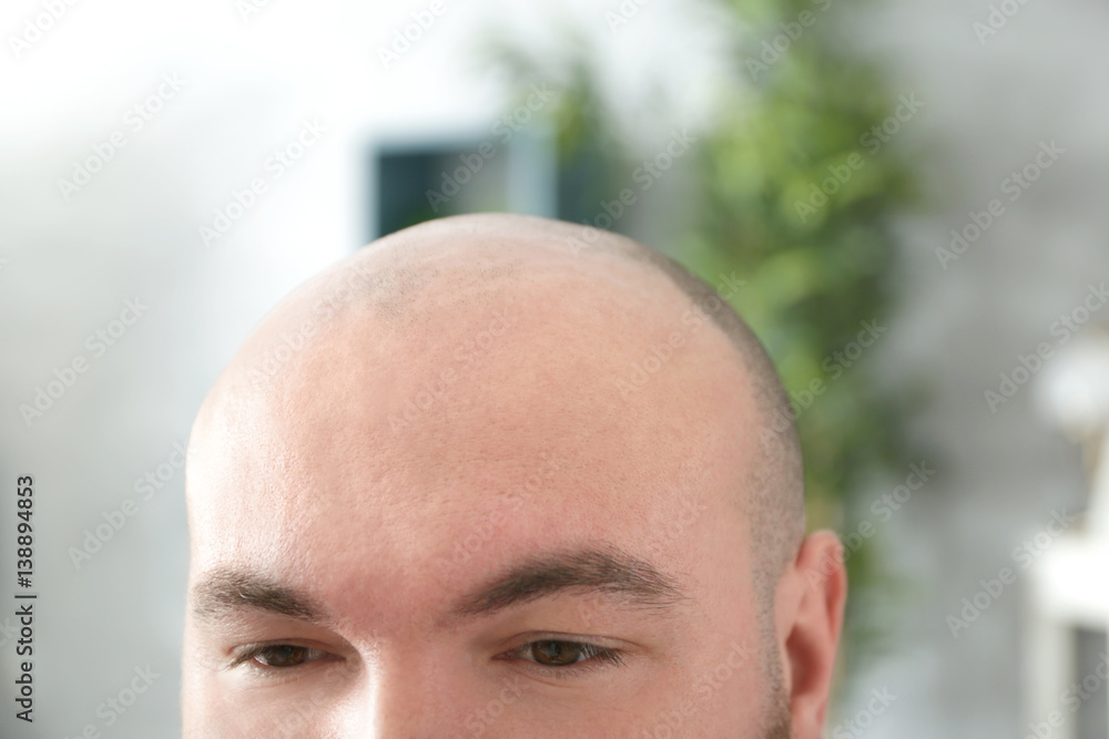 Fototapeta premium Bald adult man on blurred background, closeup