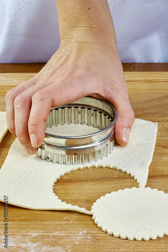 Making Croissant Cookies with Jam. Series. Cutting dough with cutter photo