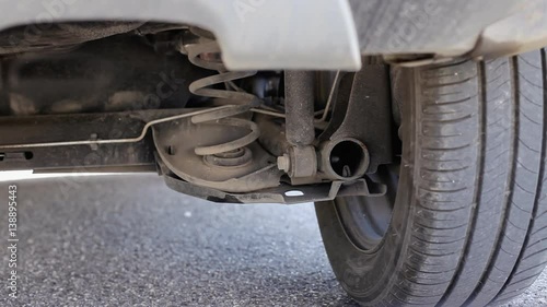 The exhaust pipe of a car starting, warming up, stepping on the gas. No visible gas, clean diesel emissions. Detail shot.
 photo