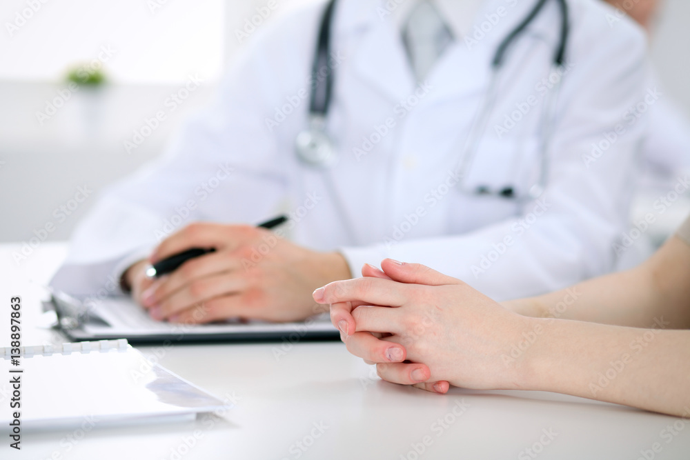 Doctor and patient are discussing something, just hands at the table Doctor and patient are discussing something, just hands at the table