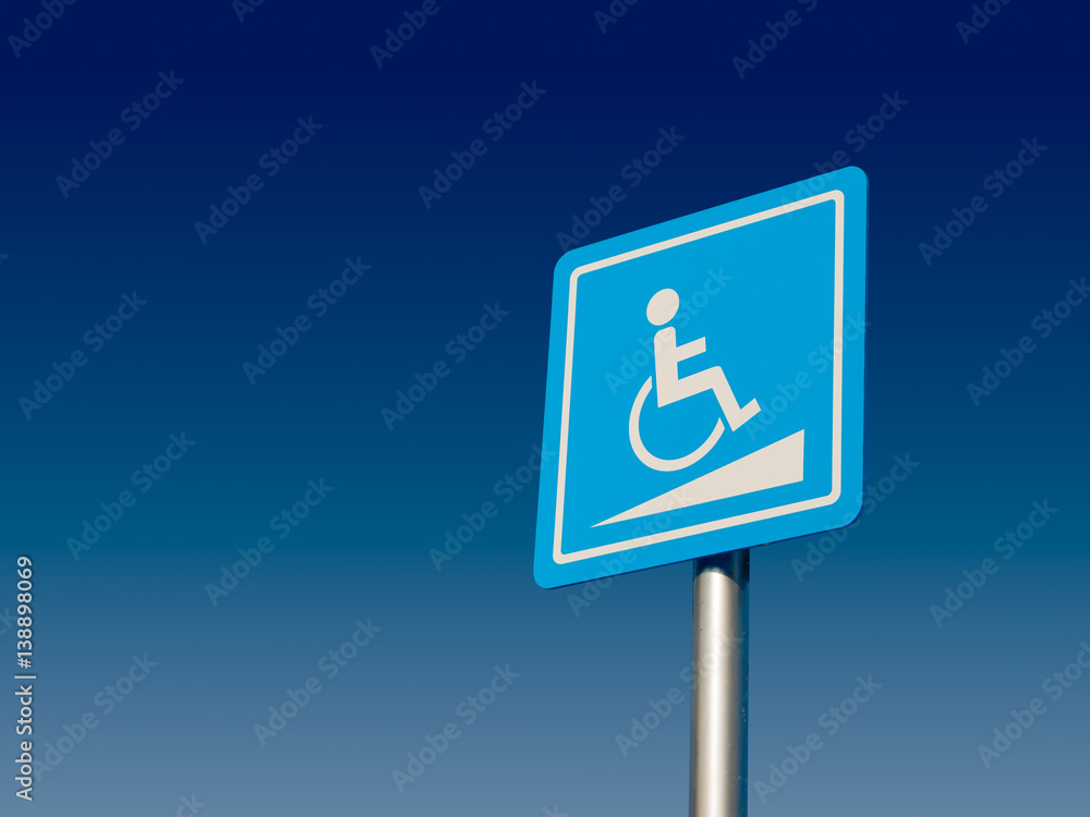 Disabled parking space and wheelchair way sign and symbols on a pole warning motorists Disabled parking space and wheelchair way sign and symbols on a pole warning motorists