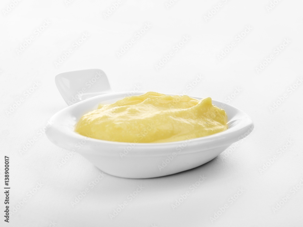 Creamy cheese in small modern saucer with comfortable handle, isolated on white Creamy cheese in small modern saucer with comfortable handle, isolated on white