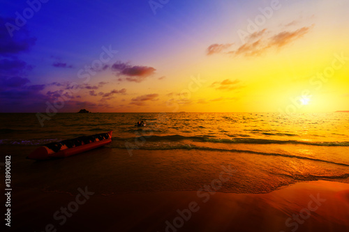 Banana boat and tugboat in sunset