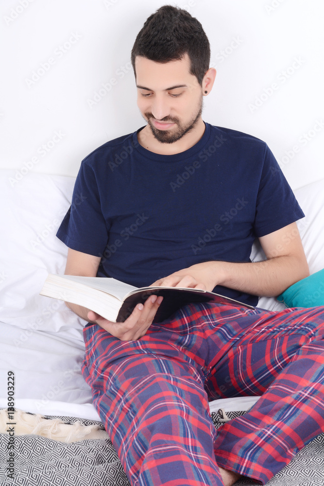 Man reading a book in bed. Man reading a book in bed.