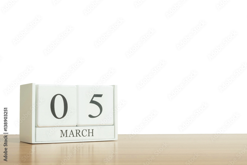 Closeup surface white wooden calendar with black 5 march word on blurred brown wood desk isolated on white background with copy space , selective focus at the calendar Closeup surface white wooden calendar with black 5 march word on blurred brown wood desk isolated on white background with copy space , selective focus at the calendar