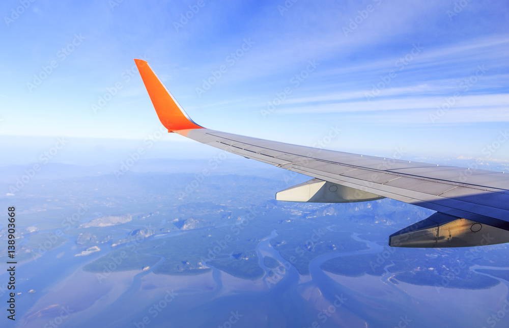 Obraz premium View from airplane window with blue sky and white clouds with soft-focus and over light