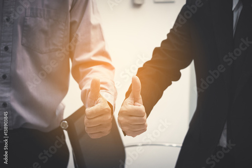 Tableau sur toile business partners thump up after business success negotiation at meeting room