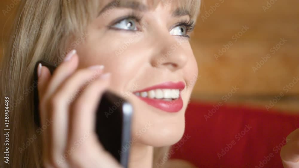 Pretty blonde woman talking on the phone at home. Pretty blonde woman talking on the phone at home.