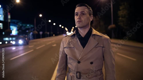 Time lapse, handsome young man in night city in middle of road, traffic. Night city, cars