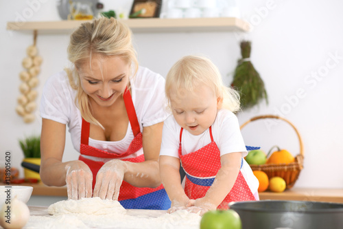 Happy family in the kitchen. Mother and child daughter cooking holiday pie or cookies for Mothers day  casual lifestyle photo series in real life interior