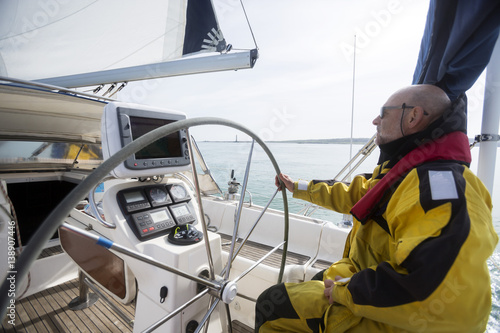 Side View Of Mature Man Steering Wheel Of Yacht