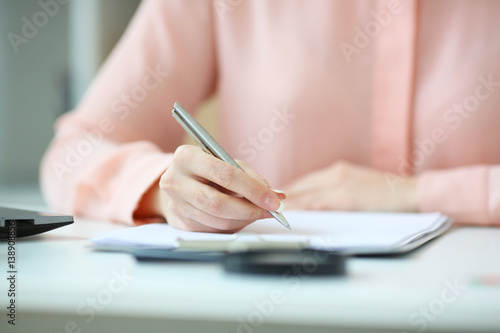 Business woman holding a pen in his hand, and signed a contract, with depth of field image photo