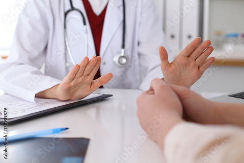 Hand of doctor  reassuring her female patient. Medical ethics and trust concept