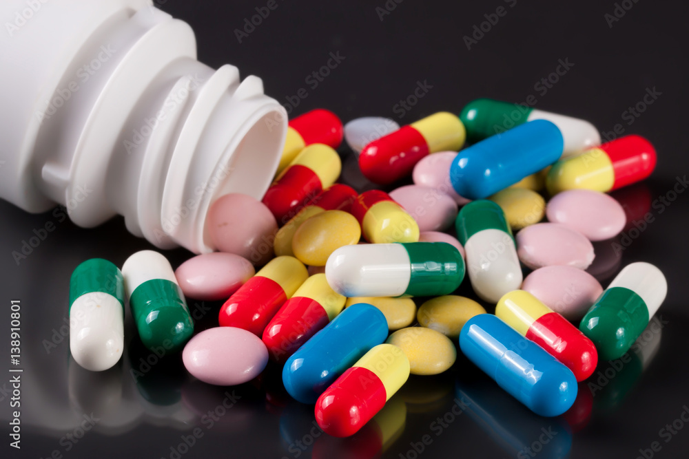 colorful pills on a dark background colorful pills on a dark background