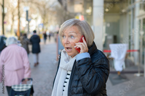 Woman shocked talking by the phone