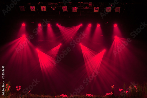 The red light from the spotlights through the smoke at the theater during the performance. Lighting equipment.