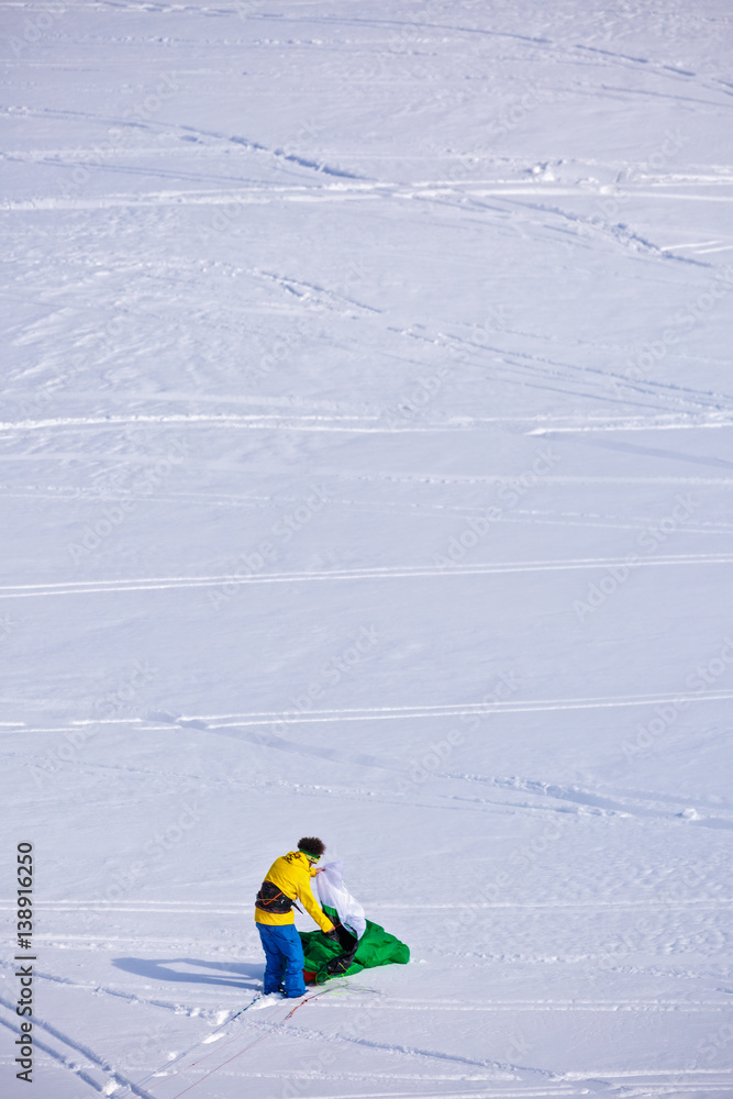 people doing kitesurfing on a frozen mountain lake people doing kitesurfing on a frozen mountain lake