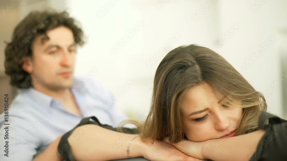 Worried couple having problems and sitting in silence on the sofa
Worried couple having problems and sitting in silence on the sofa