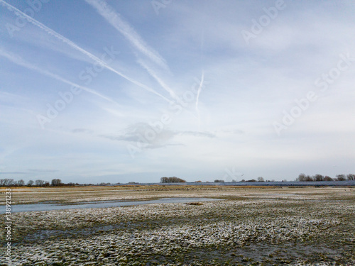 Last Snow covering field and grass under sky photo