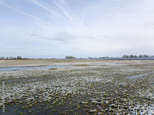 Last Snow covering field and grass under sky photo