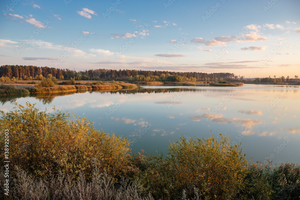 Pond in countryside in autumn at sunset